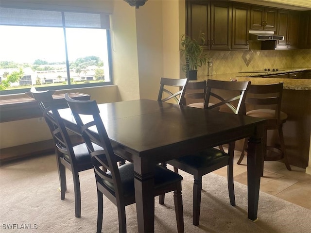 dining space featuring light carpet