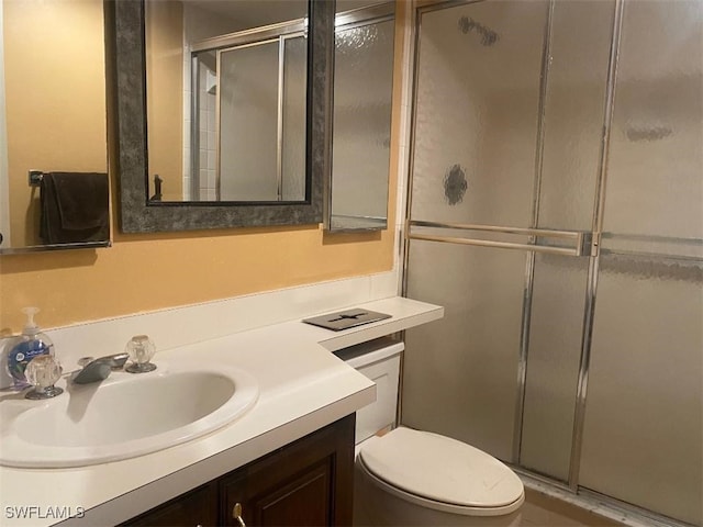 full bathroom with toilet, a stall shower, and vanity