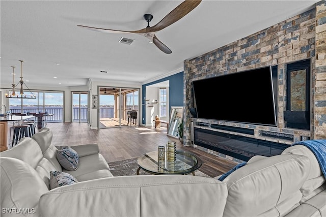 living room featuring crown molding, sink, ceiling fan with notable chandelier, and hardwood / wood-style flooring