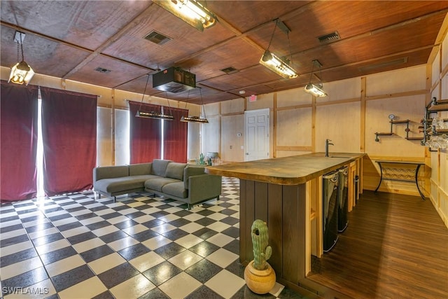 interior space featuring sink, hanging light fixtures, wooden ceiling, butcher block countertops, and wooden walls