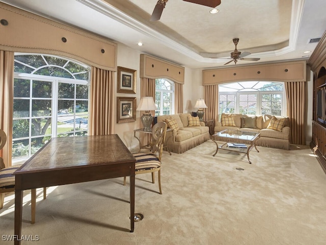 carpeted living room with visible vents, ceiling fan, ornamental molding, a tray ceiling, and recessed lighting