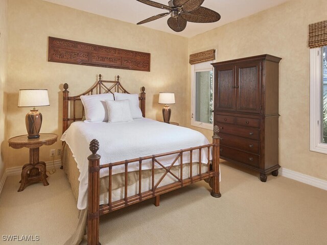 bedroom with baseboards and light colored carpet