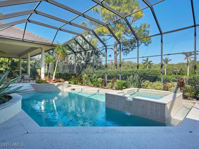 pool featuring glass enclosure, a patio, and an in ground hot tub