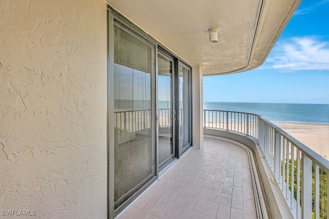 balcony featuring a water view and a view of the beach