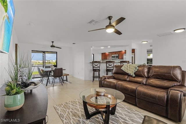 tiled living room with ceiling fan