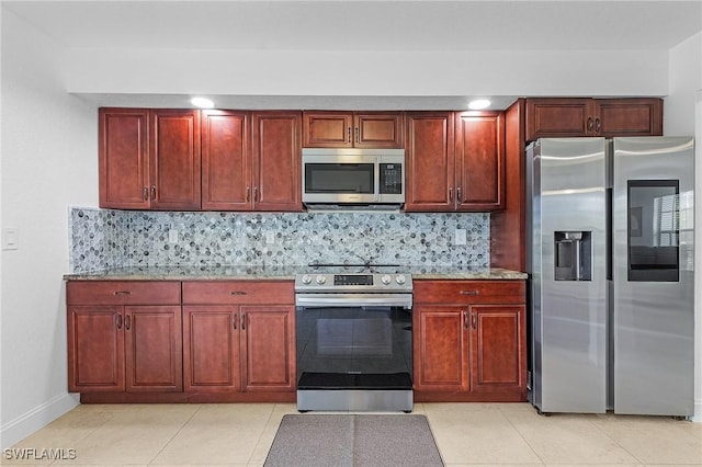 kitchen featuring decorative backsplash, light stone counters, and appliances with stainless steel finishes