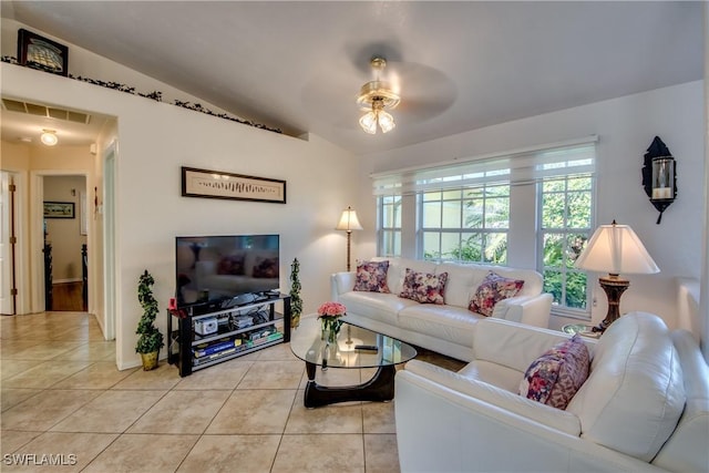 tiled living room featuring ceiling fan and vaulted ceiling