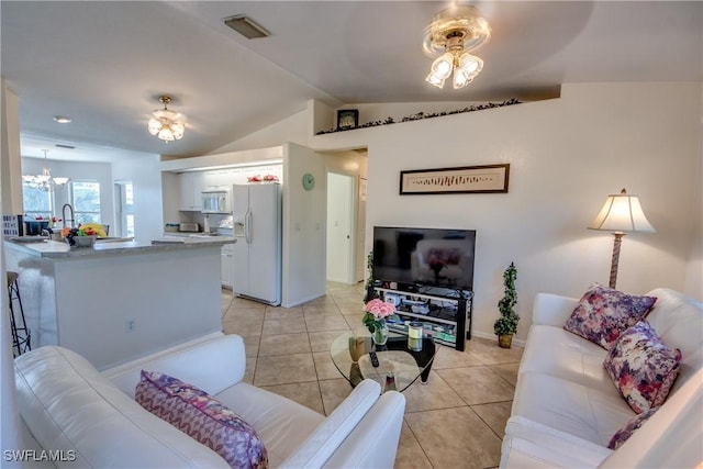 living room featuring light tile patterned flooring, vaulted ceiling, and an inviting chandelier