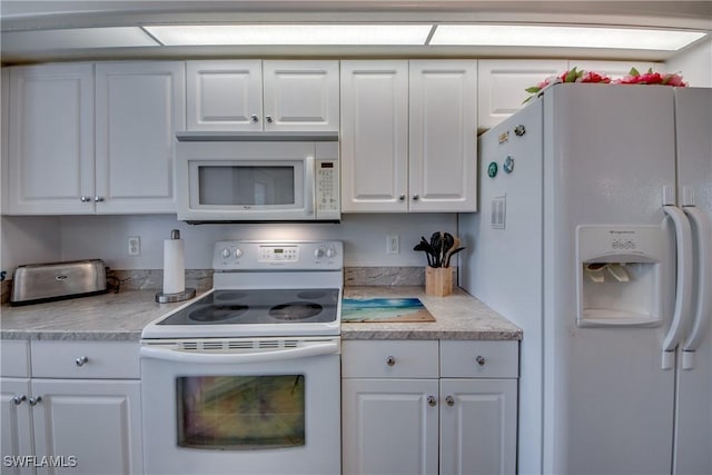 kitchen featuring white cabinetry and white appliances