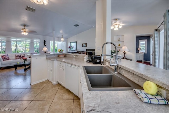 kitchen featuring white dishwasher, a healthy amount of sunlight, white cabinets, and lofted ceiling