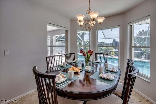 dining area featuring light tile patterned flooring, a wealth of natural light, and an inviting chandelier