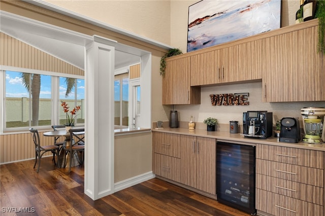 kitchen featuring light brown cabinets, dark hardwood / wood-style floors, beverage cooler, and lofted ceiling