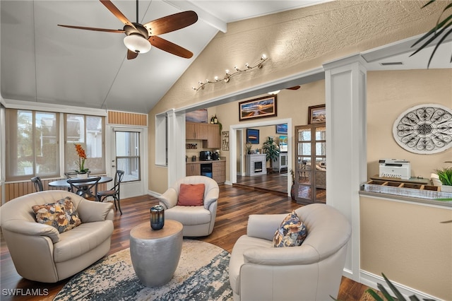 living room featuring vaulted ceiling with beams, dark hardwood / wood-style floors, ceiling fan, and decorative columns