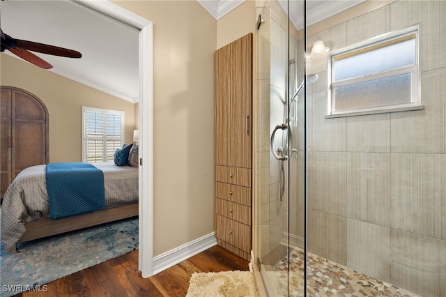 bathroom with ceiling fan, hardwood / wood-style floors, a shower with shower door, and ornamental molding