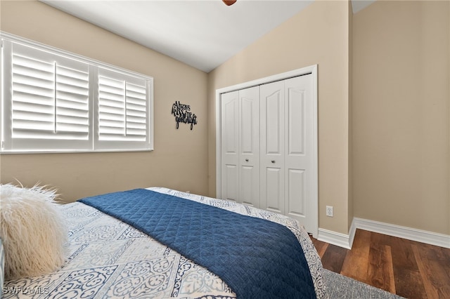 bedroom featuring dark hardwood / wood-style flooring, ceiling fan, a closet, and lofted ceiling