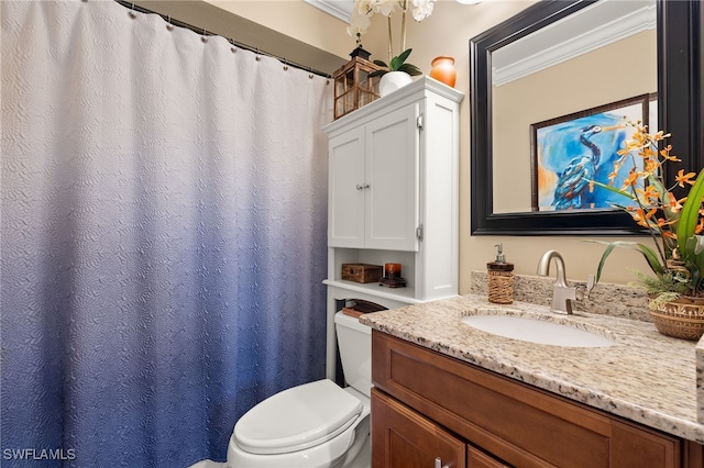 bathroom with vanity, toilet, and ornamental molding