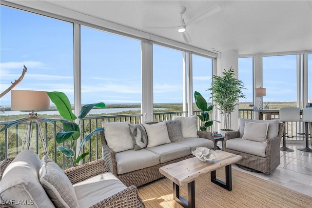 sunroom / solarium featuring a water view and ceiling fan