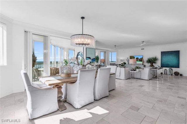 dining area featuring crown molding, a water view, and ceiling fan with notable chandelier