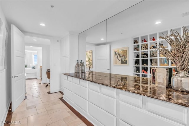 kitchen with white cabinetry and dark stone countertops