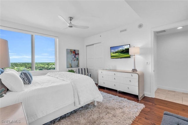 bedroom with ceiling fan, a closet, and dark hardwood / wood-style floors