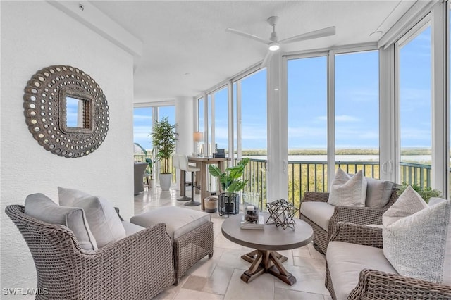 sunroom featuring a water view and ceiling fan