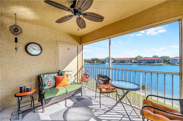 sunroom / solarium with a wealth of natural light, ceiling fan, and a water view