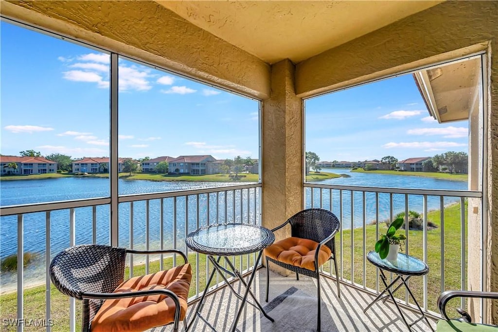 sunroom featuring a water view