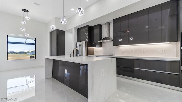 kitchen with sink, wall chimney exhaust hood, backsplash, stainless steel fridge, and pendant lighting