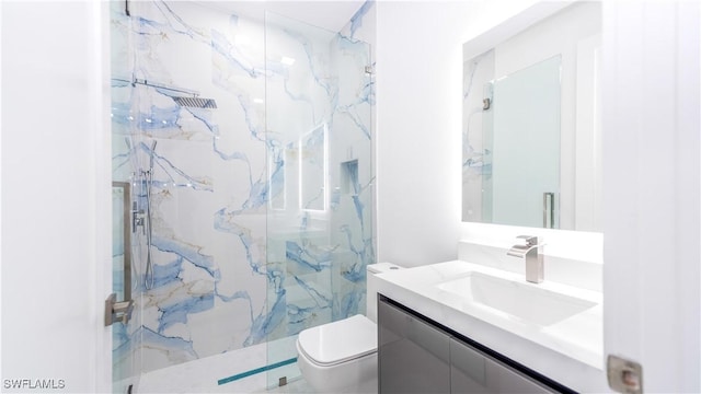 bathroom with vanity, an enclosed shower, and toilet