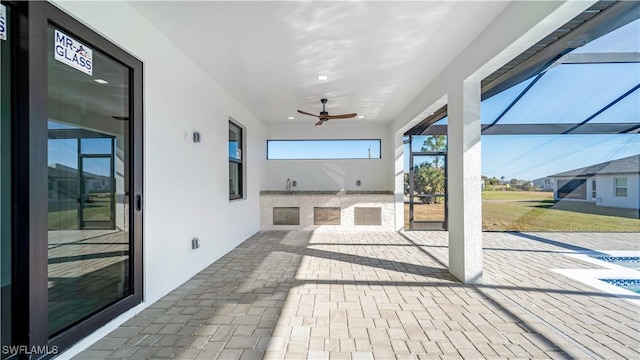 view of patio with glass enclosure and ceiling fan