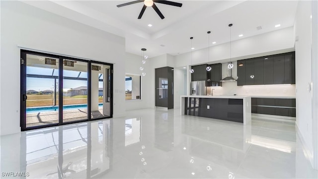 kitchen featuring stainless steel fridge with ice dispenser, decorative light fixtures, ceiling fan, and wall chimney range hood