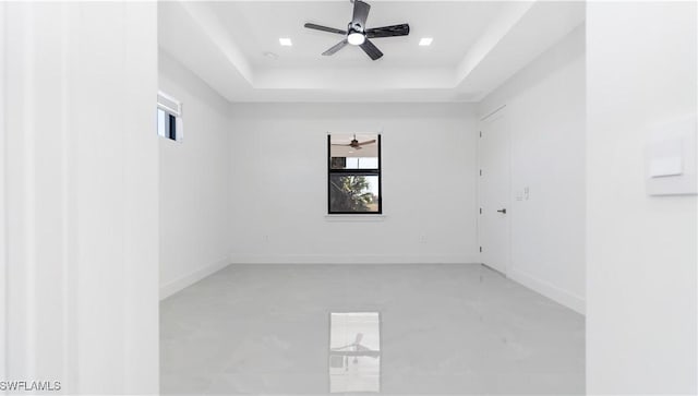 spare room featuring a raised ceiling and ceiling fan