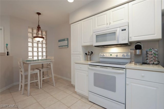 kitchen with light tile patterned floors, white appliances, decorative light fixtures, and white cabinetry