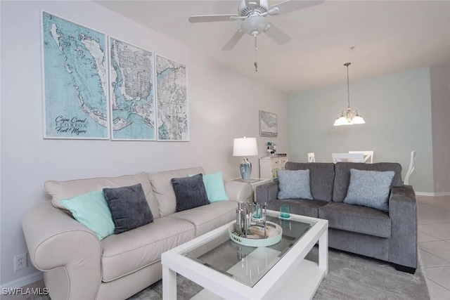 living room featuring light tile patterned flooring and ceiling fan with notable chandelier