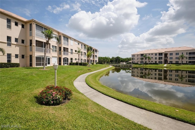 surrounding community with a yard and a water view