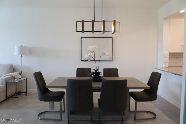 dining room with light tile patterned floors and an inviting chandelier