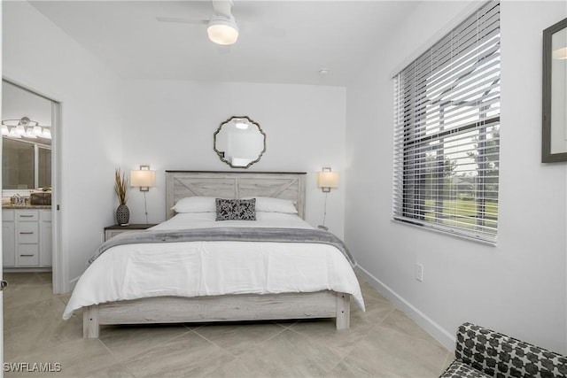 bedroom featuring ensuite bath, a ceiling fan, and baseboards