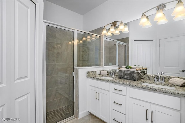 bathroom with tile patterned floors, a shower with door, and vanity