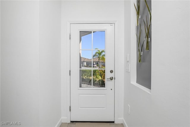 doorway featuring baseboards