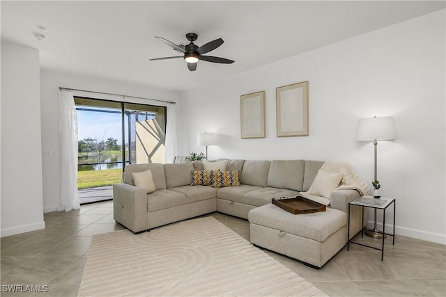 living room featuring a water view, light tile patterned floors, and ceiling fan