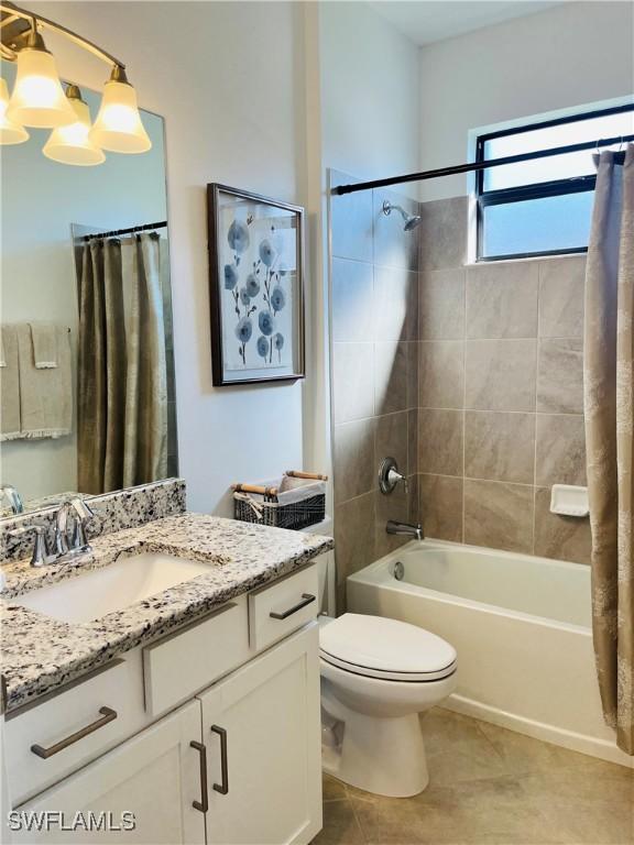 bathroom with toilet, shower / tub combo, tile patterned floors, and vanity