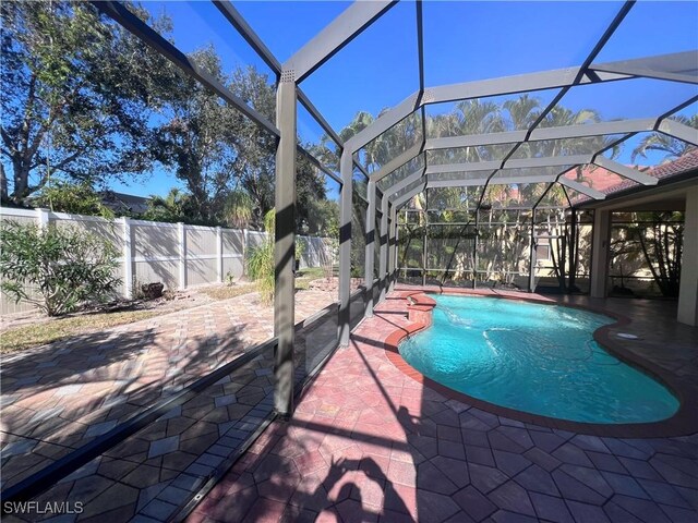 view of swimming pool featuring a lanai and a patio