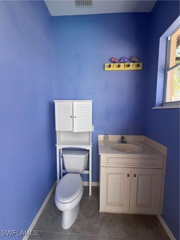 bathroom featuring toilet, vanity, and tile patterned flooring