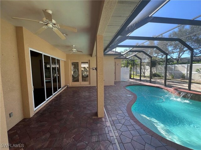 view of swimming pool with french doors, pool water feature, ceiling fan, a lanai, and a patio