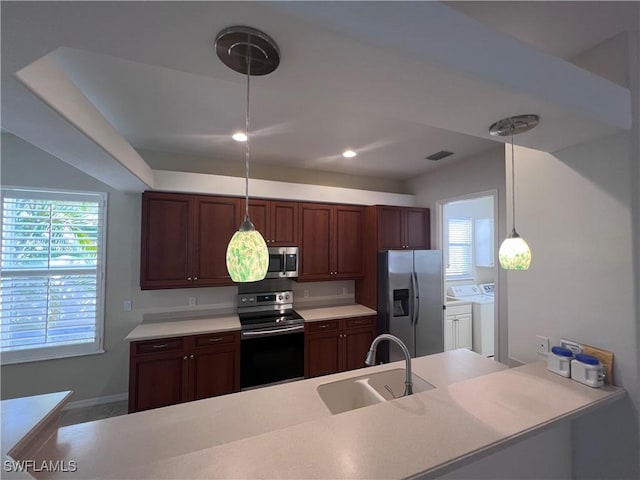 kitchen with washing machine and dryer, a healthy amount of sunlight, sink, and stainless steel appliances