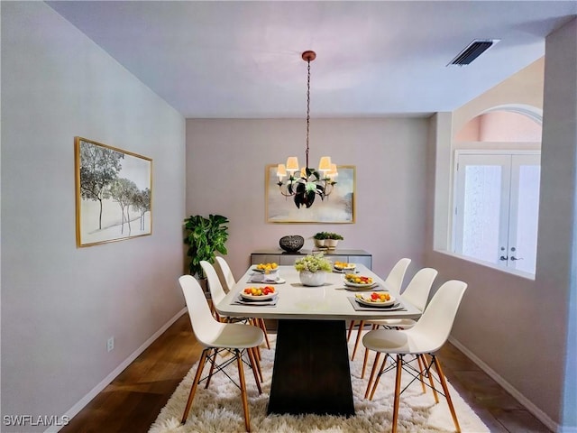 dining room featuring hardwood / wood-style flooring and a notable chandelier