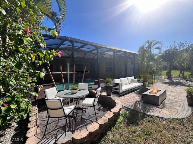 view of patio featuring an outdoor living space with a fire pit and glass enclosure