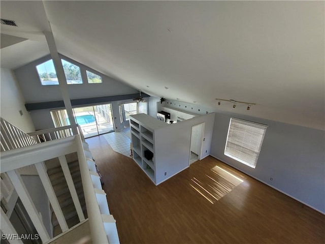 unfurnished living room featuring ceiling fan, wood-type flooring, high vaulted ceiling, and a skylight