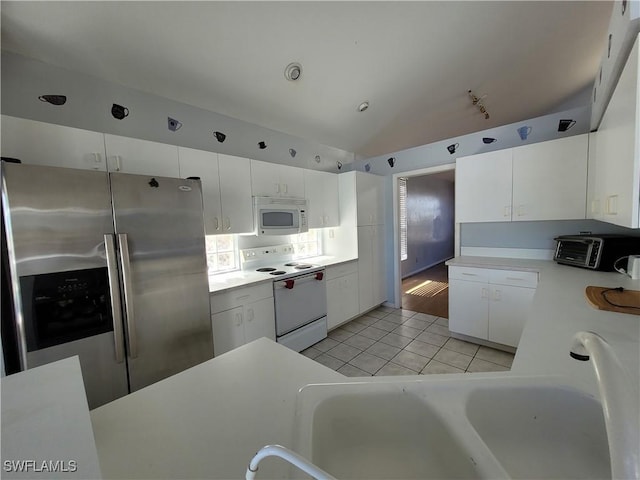 kitchen with white cabinets, white appliances, and vaulted ceiling