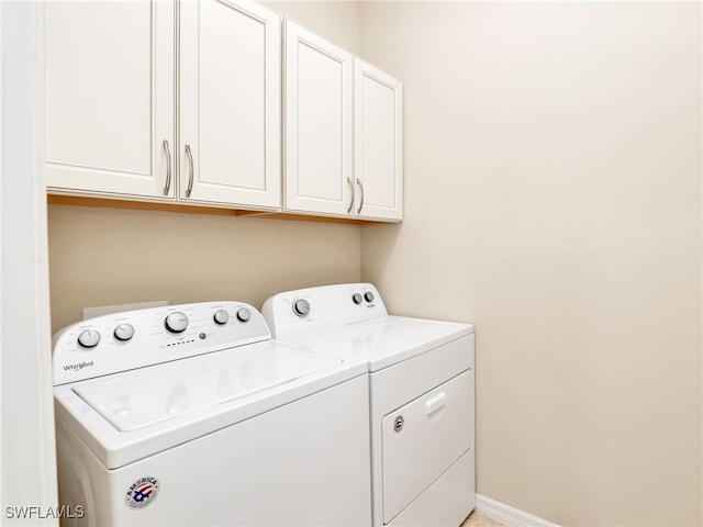 laundry room with cabinets and washer and clothes dryer